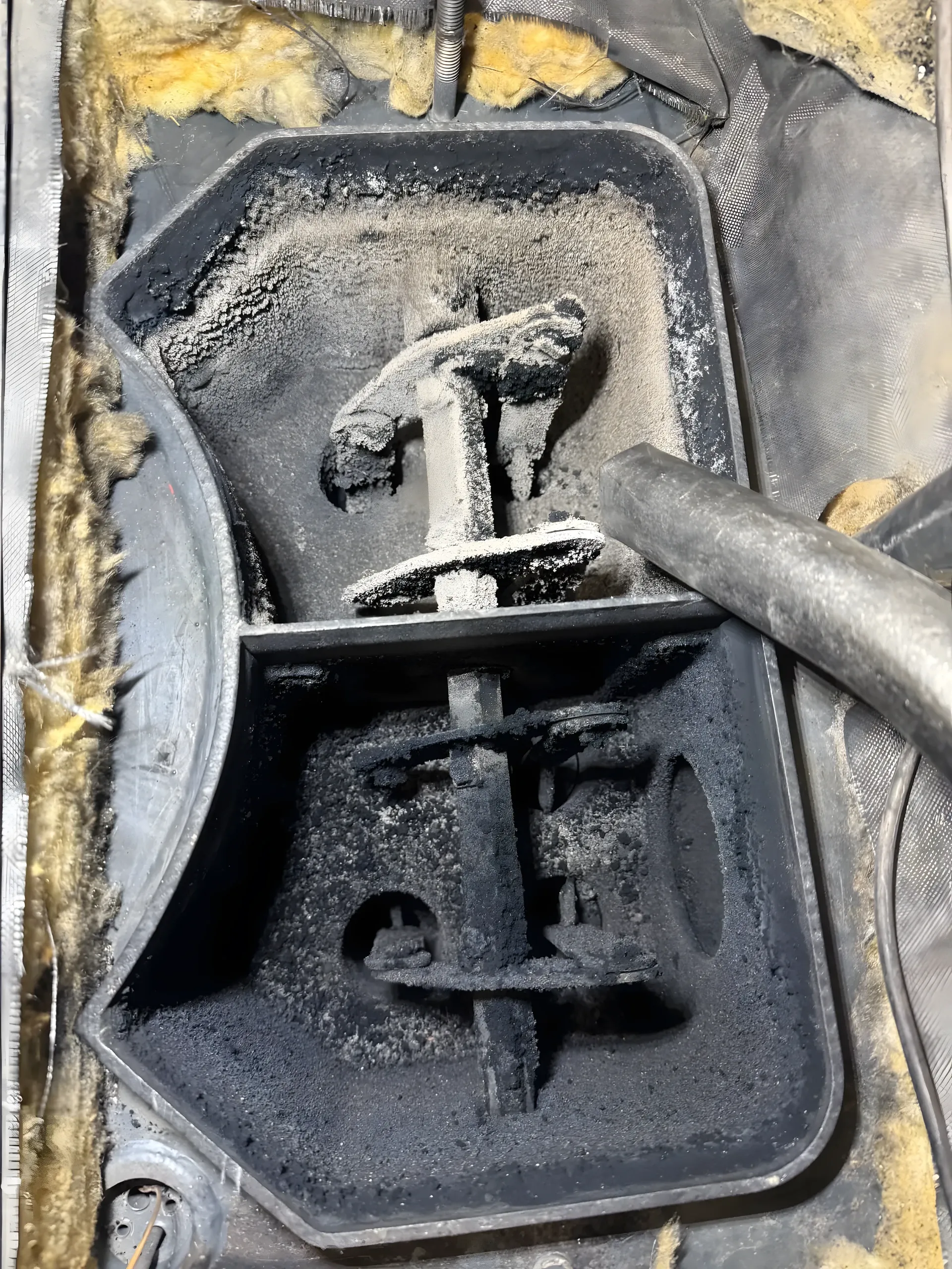 Compartiments d'échange d'une chaudière à bois remplis de cendre et de suie avant décendrage