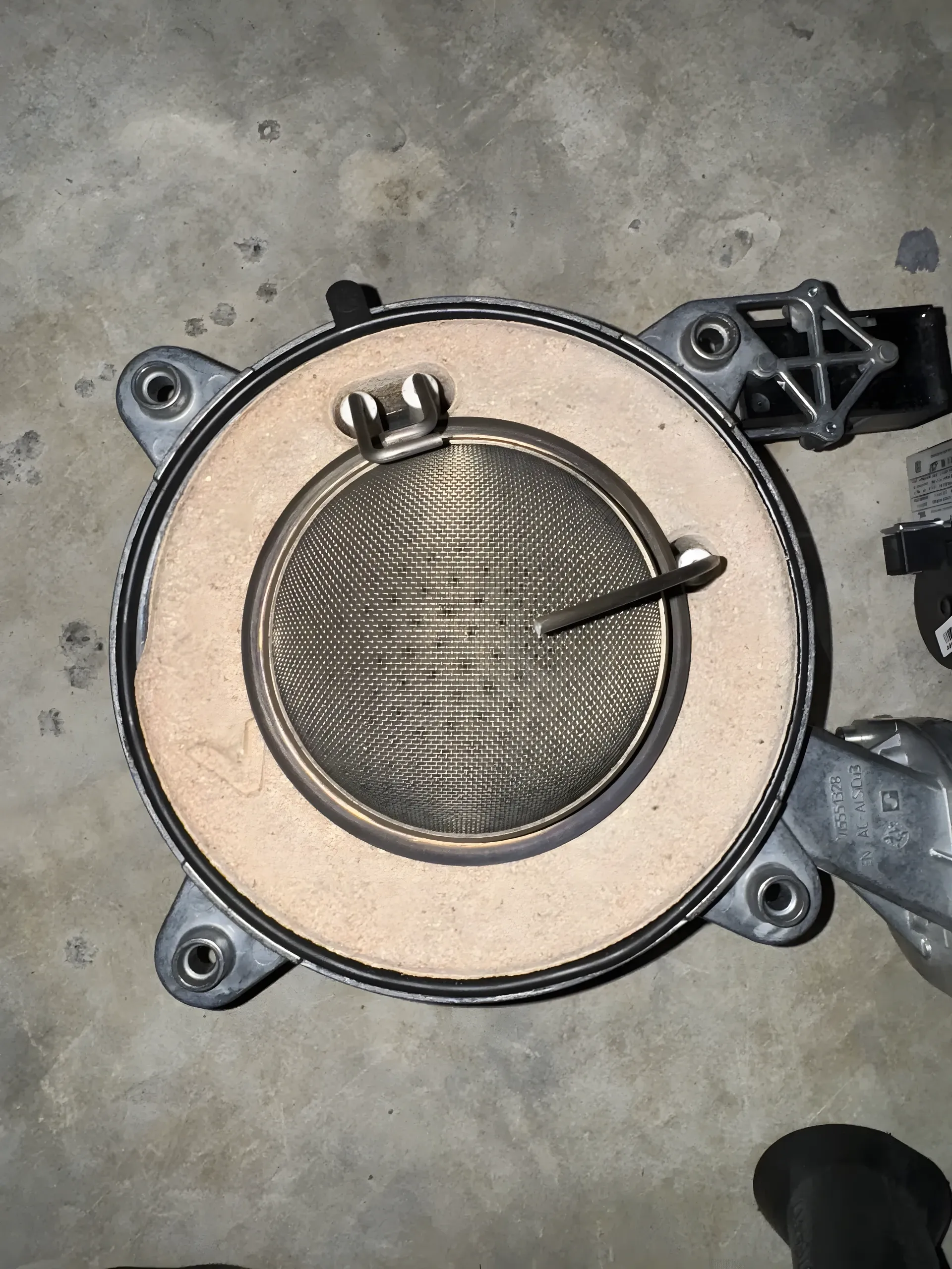 La même grille de brûleur après nettoyage, inox propre et perforations dégagées