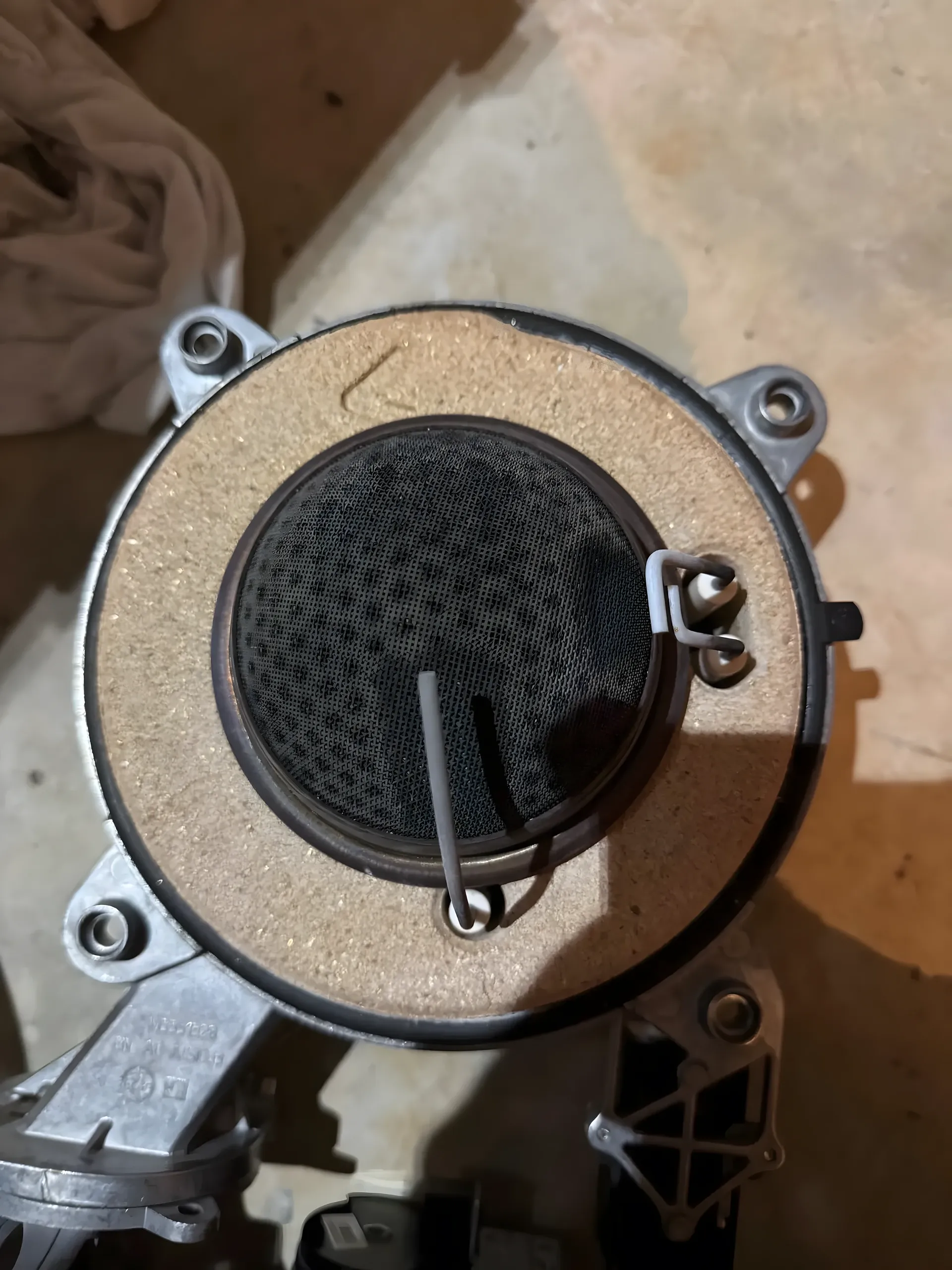 Grille inox du brûleur à prémélange d'une chaudière à gaz, tachetée de suie avant nettoyage