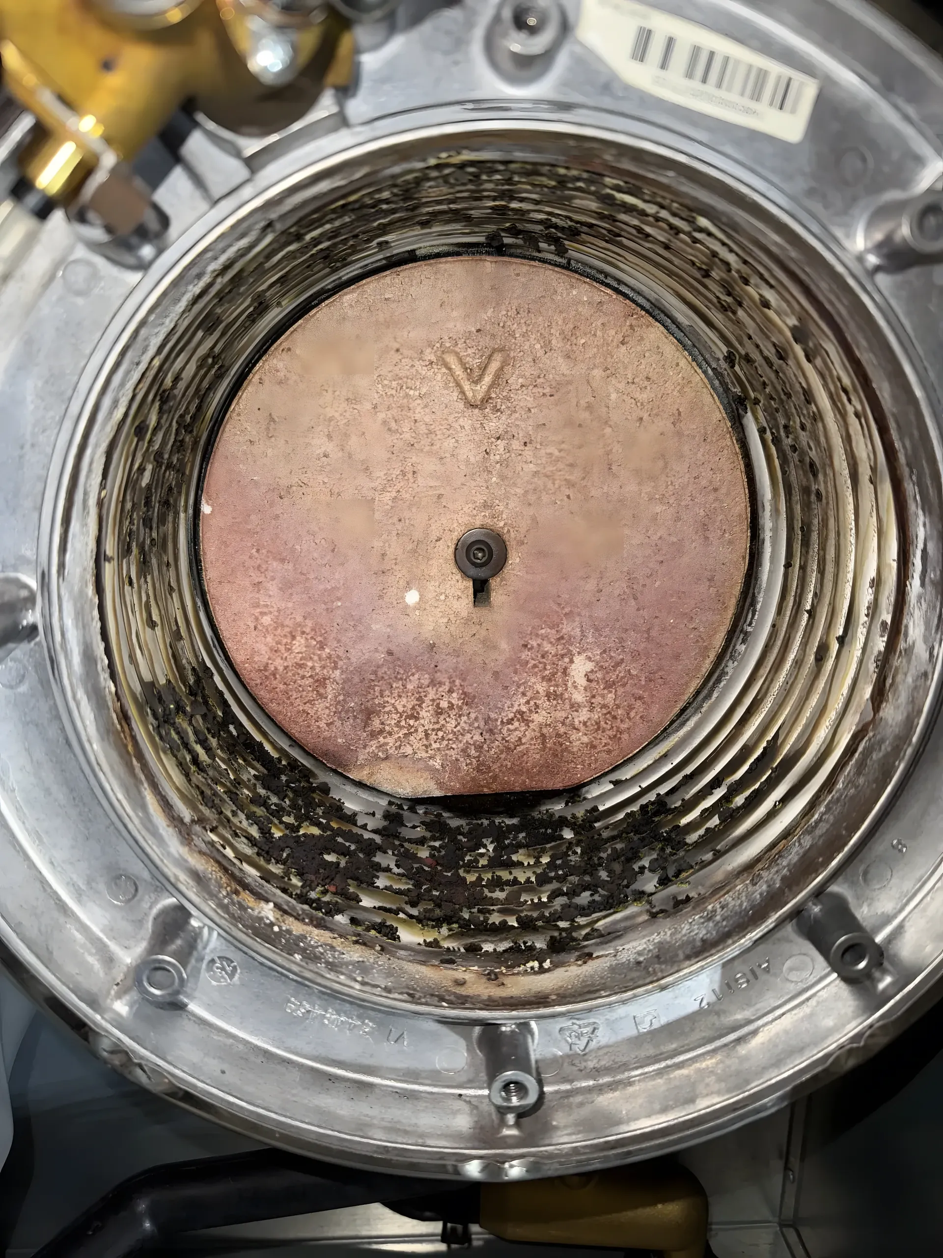Échangeur à condensation d'une chaudière à gaz, dépôts noirs accumulés entre les lamelles avant l'entretien