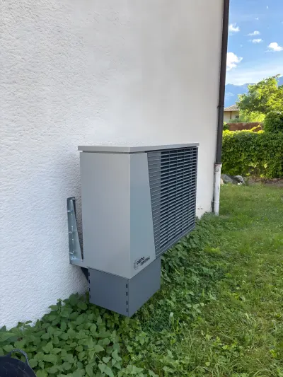 Unité extérieure alpha innotec de la pompe à chaleur air-eau sur sa console murale, côté jardin, chantier de Genève