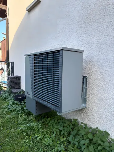 Pompe à chaleur air-eau alpha innotec vue de trois quarts contre la façade, chantier de Genève